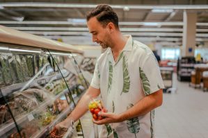 Handsome man searching for groceries from the list on mobile phone