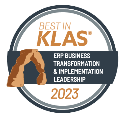 A circle logo that says Best in Klas (trademark) - ERP Business Transformation and Implementation Leadership 2023, with a drawing of a natural brown stone archway.